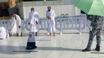 رجل أمن يظل طفلة من حرارة الشمس  تصلي في الحرام المكي- صور