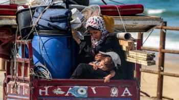 A Journey of Displacement on Wheels… A Mother Carrying Her Child and Memories Amid the Rubble
